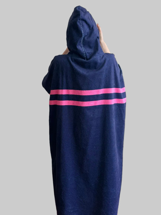Navy blue poncho with pink stripes on a gray background