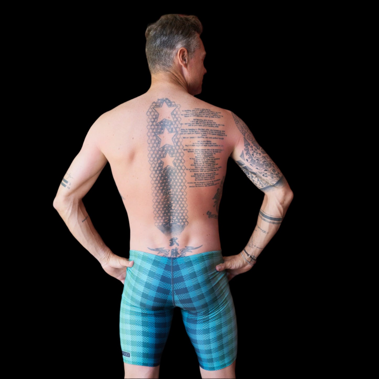 Fit Man wearing green checkered pattern Jammers standing with hands on hips