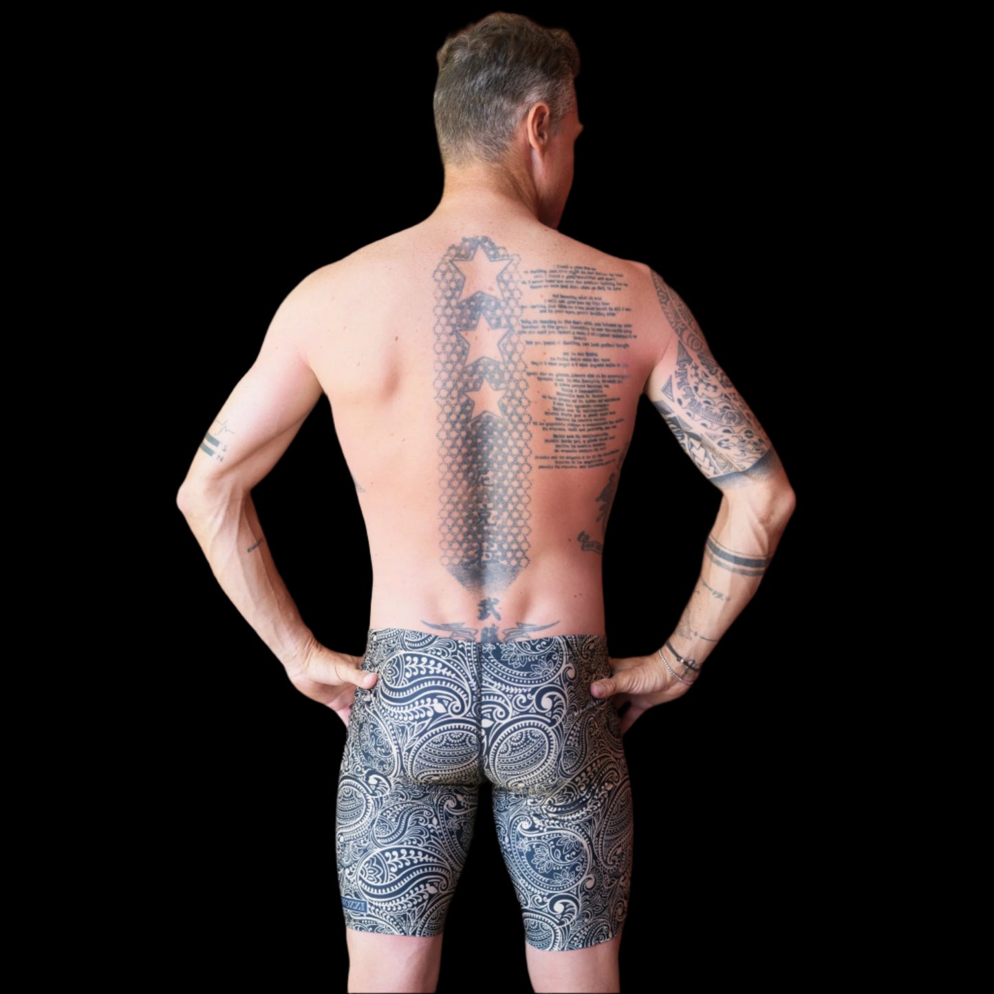 Fit Man wearing gold and black paisley pattern Jammers standing with hands on hips