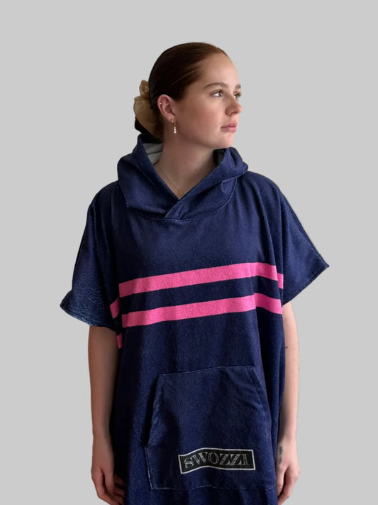 Person wearing a navy poncho with pink stripes and 'Swoop!' logo on a gray background