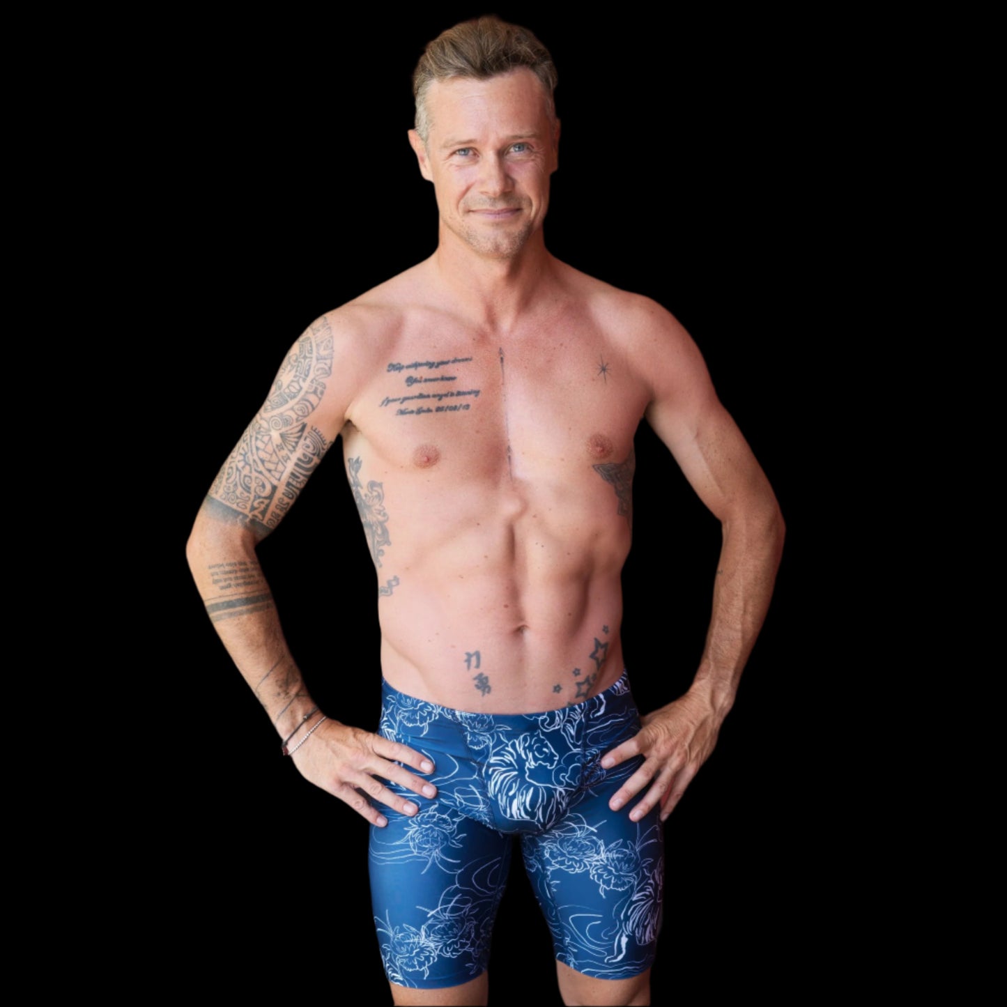 Fit Man wearing blue tiger and flower pattern Jammers standing with hands on hips
