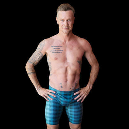 Fit Man wearing green checkered pattern Jammers standing with hands on hips