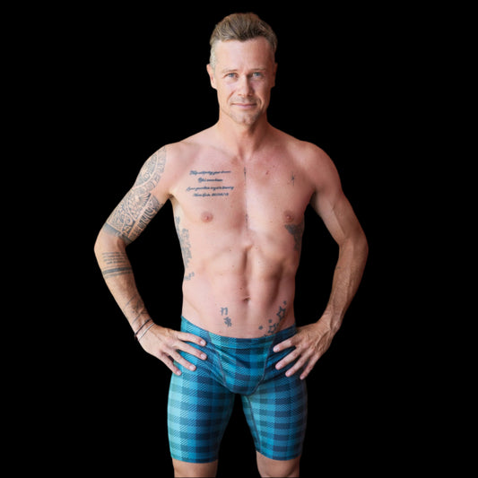 Fit Man wearing green checkered pattern Jammers standing with hands on hips