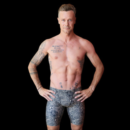 Fit Man wearing gold and black paisley pattern Jammers standing with hands on hips