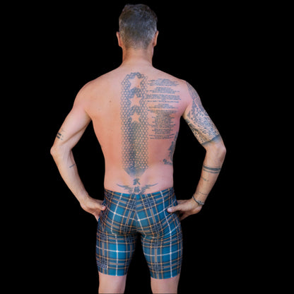 Fit Man wearing green scottish tartin pattern Jammers standing with hands on hips

