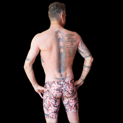 Fit Man wearing wild foilage leaf pattern Jammers standing with hands on hips
