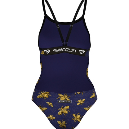 Navy blue swimsuit with Gold bee pattern and 'Swozzi' branding on a white background