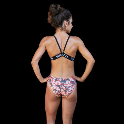 Fit Women wearing brown Leaf Foilage pattern one piece swimwear with a brand logo  with adjustable straps and supported elastic