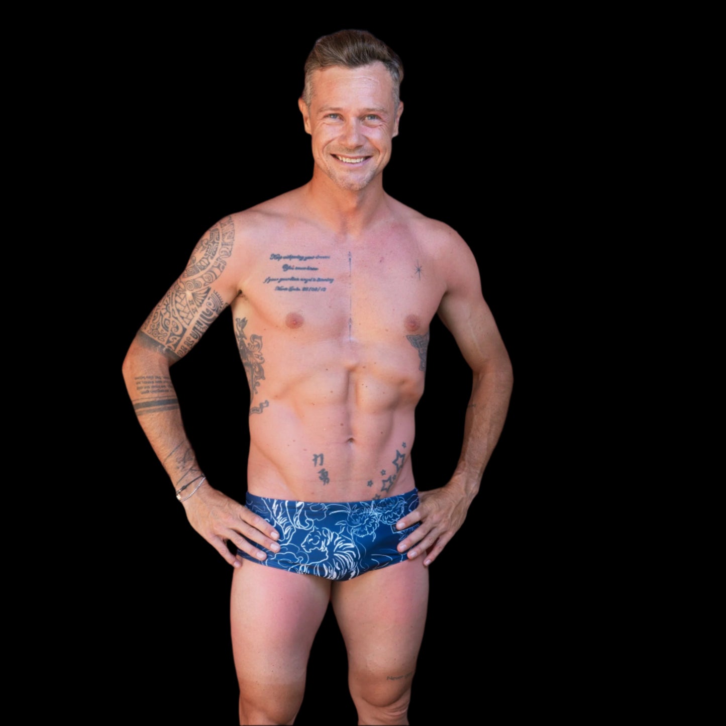 Fit man wearing Blue Flower Tiger pattern one piece swimwear with a brand logo  hands on hips
