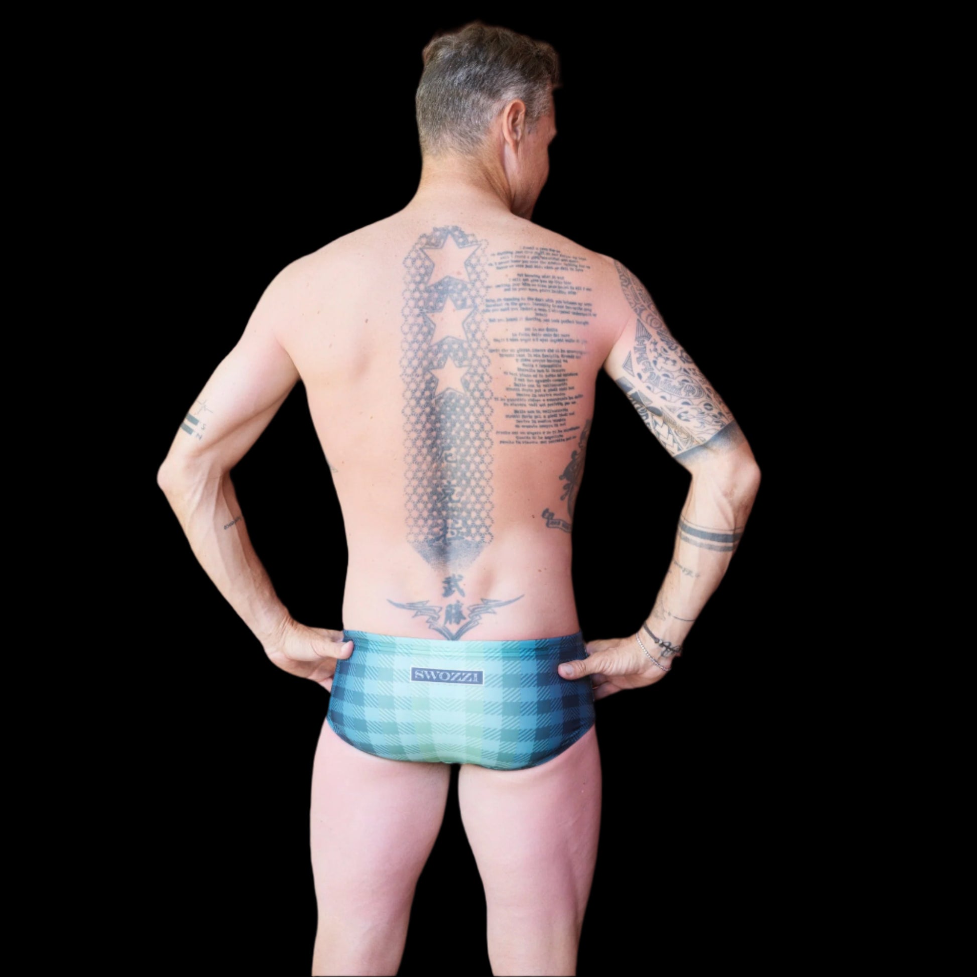 Fit man wearing Green Checkered pattern one piece swimwear with a brand logo  hands on hips