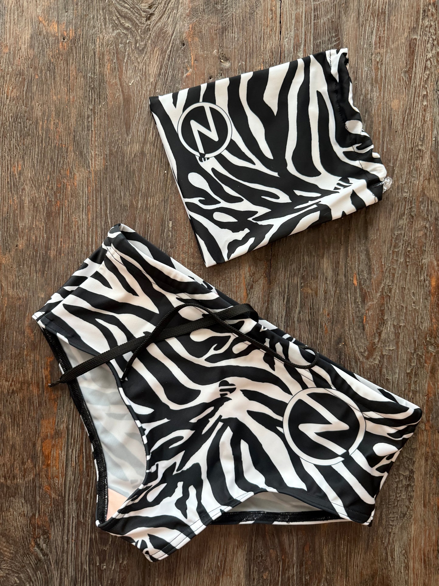Black and white zebra print swimsuit on a wooden surface