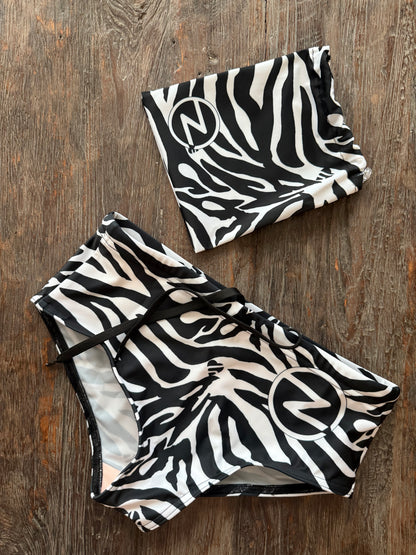 Black and white zebra print swimsuit on a wooden surface